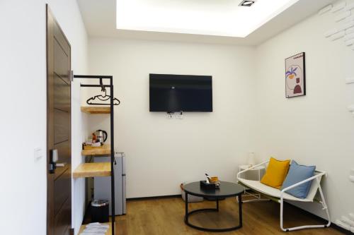 a living room with a tv on a white wall at 清境依山舞林民宿 in Renai