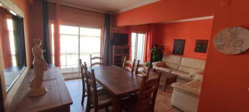 a living room with a table and a dining room at Correia Holiday Apartment in Fuzeta
