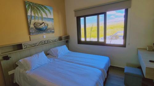 a bedroom with a blue bed and a window at STAY Chrystallia Holiday Villa in Anarita