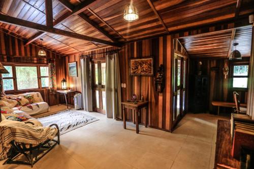 a large living room with wooden walls and ceilings at Sitio Bom Tempo in Miguel Pereira