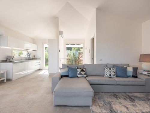 a living room with a gray couch and a kitchen at Villa Latisa in Terra Mala