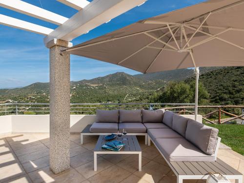 a patio with a couch and an umbrella at Villa Latisa in Terra Mala