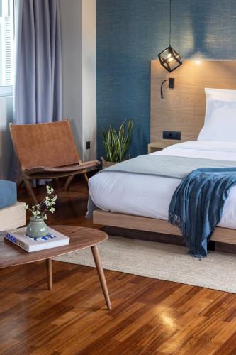 a bedroom with a bed and a chair and a table at Arcade Hotel Athens in Athens
