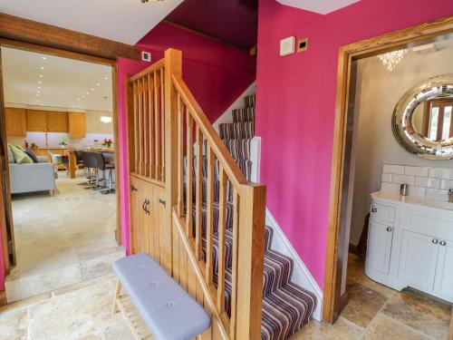 a staircase in a room with pink walls at The Stables in Stourbridge