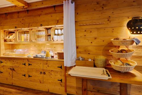 a kitchen with wooden walls and a counter with baskets at Sennerhütte Landhotel in Kurort Gohrisch