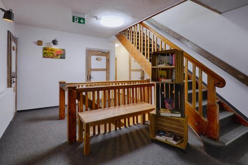 a room with a wooden staircase with a bench at Sennerhütte Landhotel in Kurort Gohrisch