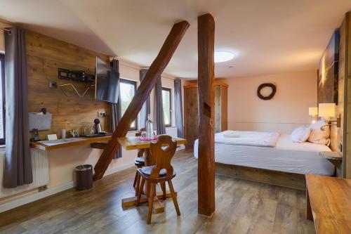 a bedroom with a bed and a table and a kitchen at Sennerhütte Landhotel in Kurort Gohrisch