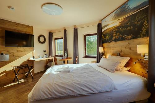 a bedroom with a large bed with a painting on the wall at Sennerhütte Landhotel in Kurort Gohrisch