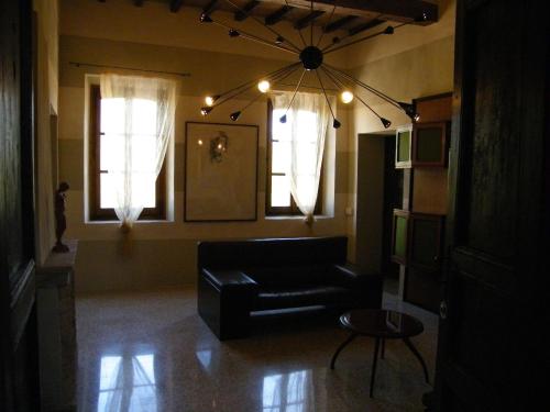 a living room with a black couch and two windows at Room and Breakfast Torre in Felino