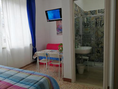 1 dormitorio con mesa, lavamanos y TV en B&B Laura e Chiara, en Trapani