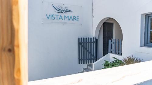a white building with a sign for a villamate at Vista Mare in Naousa
