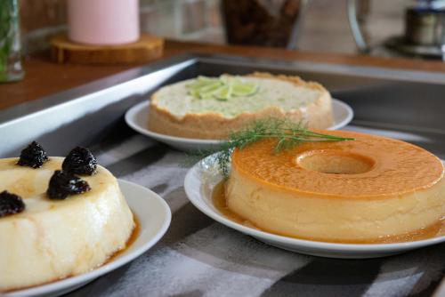 three cakes sitting on plates on a counter at Hotel Fazenda Vale da Cachoeira in Serra Negra
