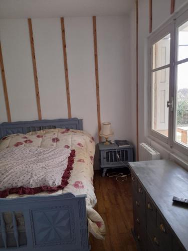 une chambre avec un lit, une commode et une fenêtre dans l'établissement Maison dans écrin de verdure en Périgord noir, à Saint-Cyprien