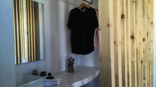 a black shirt hanging on a wall next to a sink at Vista Mare in Naousa