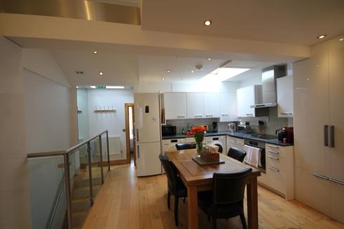 a kitchen with a wooden table and a dining room at Cambridge city centre immaculate 2 bed apartment in Cambridge