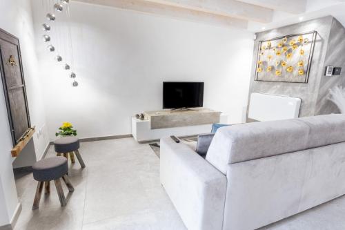 a white living room with a couch and a tv at Casa vacanza salento luxury virginia in Racale