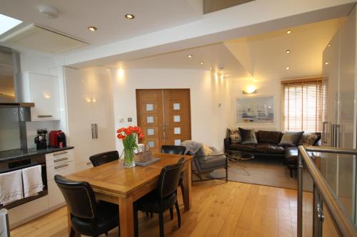 una cucina e un soggiorno con tavolo e sedie in legno di Cambridge city centre immaculate 2 bed apartment a Cambridge
