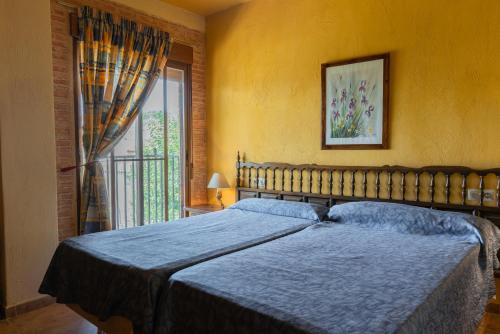 Un dormitorio con una cama grande y una ventana en Casas rurales Los Guerrero B, en Peñarrubia