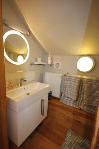 La salle de bains est pourvue d'un lavabo blanc et de deux miroirs. dans l'établissement Cambridge city centre immaculate 2 bed apartment, à Cambridge