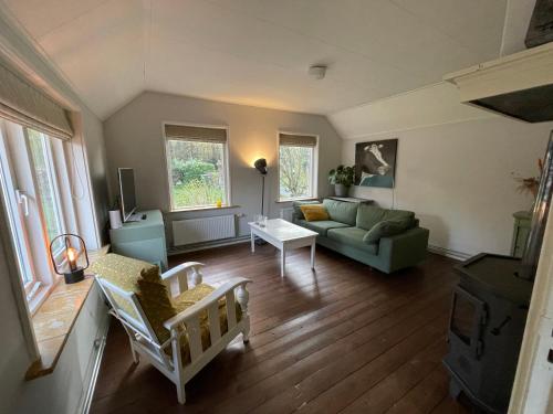 uma sala de estar com um sofá e uma mesa em Tiny house Veluwse Garre em Garderen