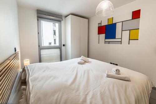 Un dormitorio con una cama blanca con toallas. en WA 2.1 ·Légo, en Toulouse