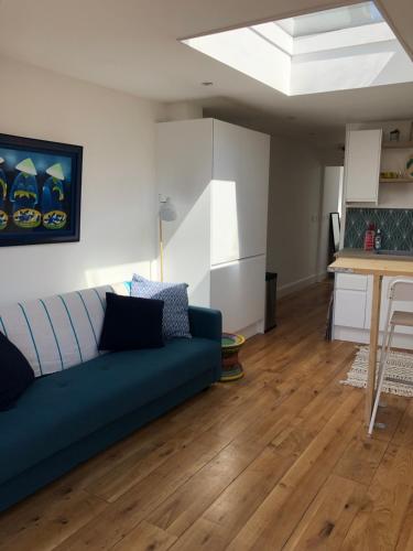 a living room with a blue couch and a table at The Shack in East Wittering