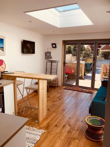 a living room with a wooden table and a skylight at The Shack in East Wittering