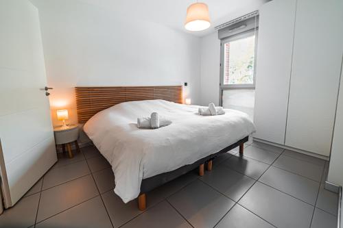 une chambre avec un grand lit blanc dans une pièce dans l'établissement Wonder Appart' 1.2 - Coeur de ville -, à Toulouse