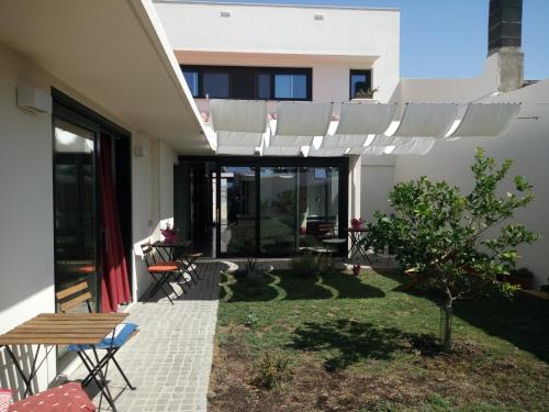 une terrasse avec une pergola blanche sur une maison dans l'établissement sa ribera, à Cabras