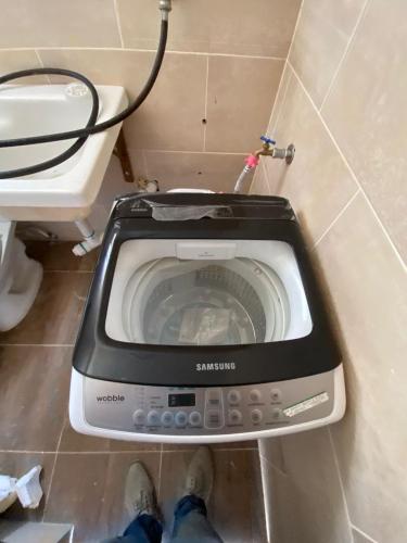 a washing machine in a bathroom next to a toilet at RESIDENCIAL DOÑA GLORIA in San Felipe de Puerto Plata