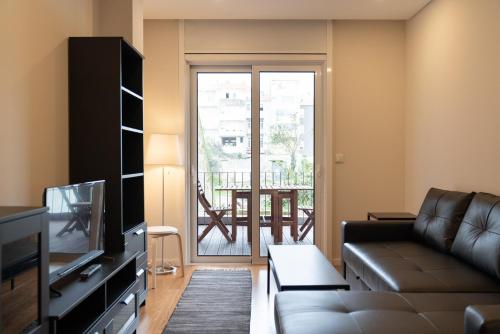 a living room with a couch and a television at Jenny Porto in Porto