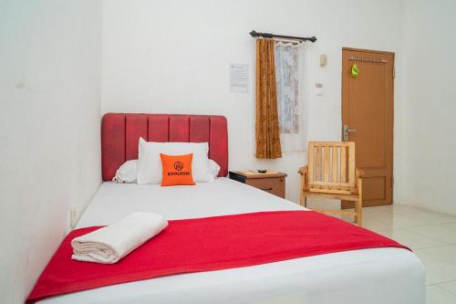 a bedroom with a large bed with an orange pillow at Koolkost syariah near Jalan Ahmad Yani Banjarmasin 2 in Sungai Lutus
