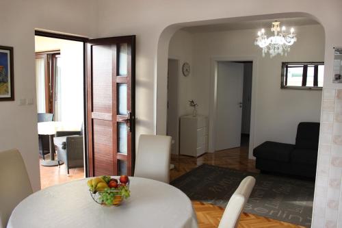 een woonkamer met een tafel met een fruitschaal erop bij Lanterna Zara Apartman in Zadar
