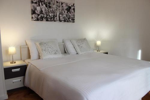 A bed or beds in a room at Lanterna Zara Apartman