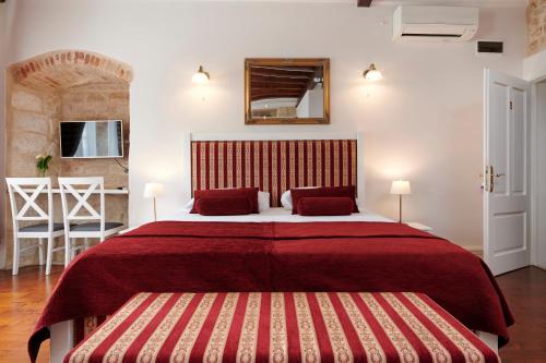 a bedroom with a large bed with a red blanket at Palace Central Square in Trogir
