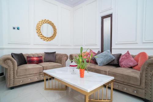 a living room with two couches and a table at RedDoorz Syariah near Jalan A Yani KM 8 Citraland in Banjarmasin