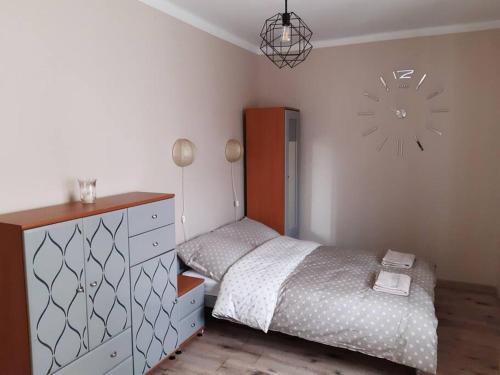 sypialnia z łóżkiem, komodą i zegarem w obiekcie Żwirki centrum w mieście Skierniewice