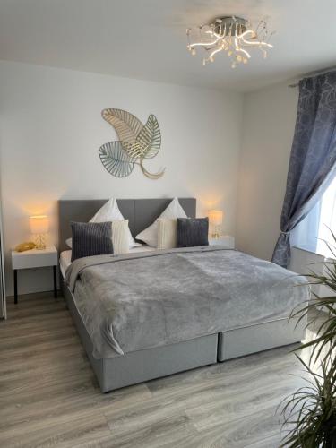 Un dormitorio con una cama grande y una lámpara de araña. en Prime Host Style Apartment, en Karlsruhe