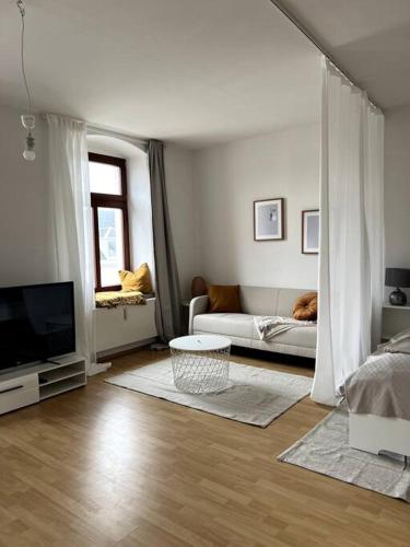 a white living room with a couch and a tv at ~In der Natur und dennoch zentral~ in Annaberg-Buchholz