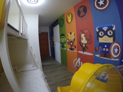 una habitación para niños con una pared temática de superhéroes en CoCo Guesthouse Kemaman, en Cukai