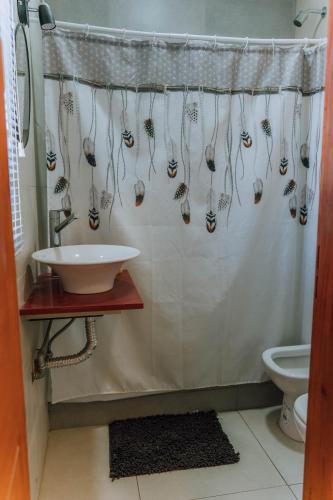 a bathroom with a shower curtain and a sink at La Tranquila in Pergamino