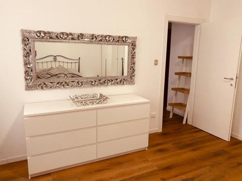 a white dresser with a mirror on a wall at Mutti Stay apartments in Riva del Garda