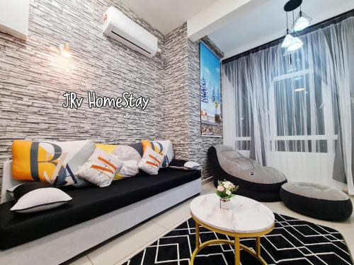 a living room with a black couch and a brick wall at JRv HotelStyle HomeStay Melaka in Melaka