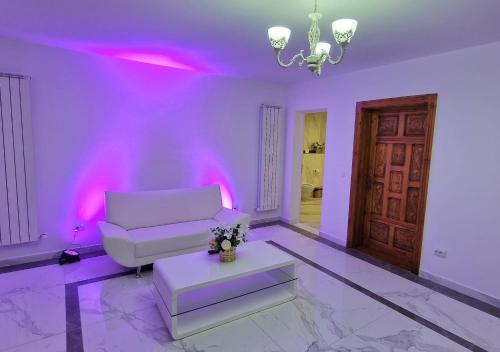 a living room with purple lighting and a couch and a table at Casa Avram in Suceviţa