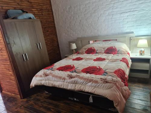 a bedroom with a bed with red roses on it at Cabañas Los Ñatos SE RESERVA CON SEÑA !!! in Barra del Chuy