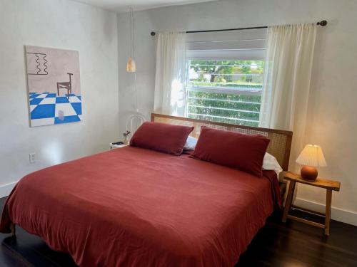 una camera da letto con un grande letto rosso e una finestra di Buenavista Bungalow at Lumicollection a Miami