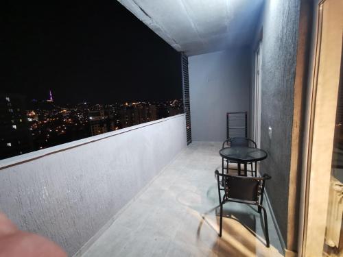 a room with a table and chairs on a balcony at ArchiC509 in Tbilisi City