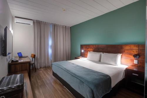 a hotel room with a large bed and a desk at Cyan Resort by Atlantica in Itupeva