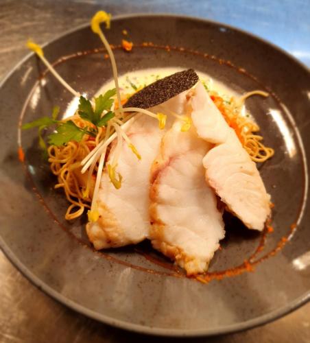 a plate of food with noodles on a table at Hotel Brimer in Grundhof