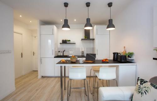 une cuisine avec une table, des chaises et un réfrigérateur dans l'établissement COSY TROPEZ, la petite Venise, Port-grimaud, à Grimaud